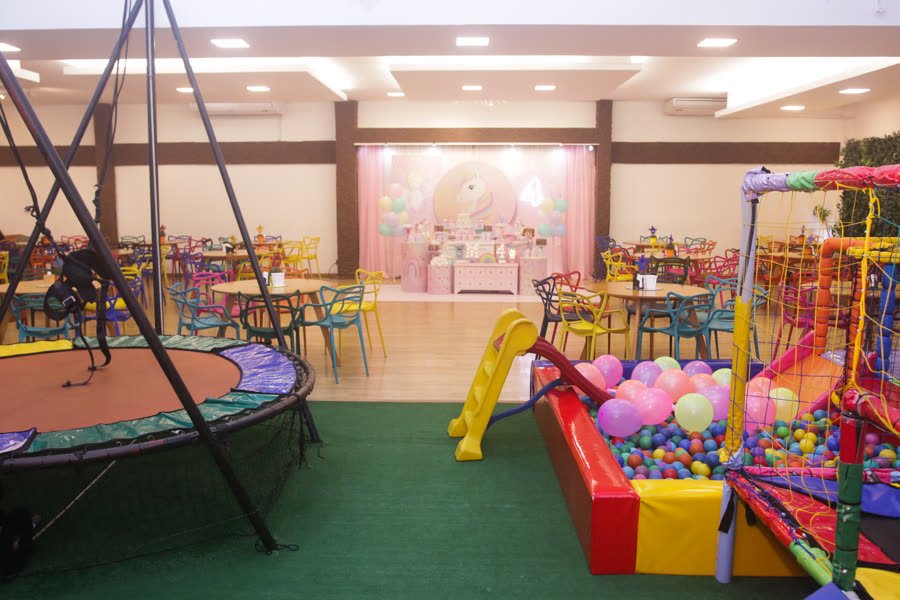 Cama elástica e piscina de bolinhas no mesmo salão das mesas